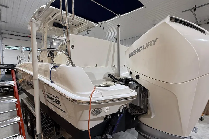 Slide: The Image of 2022 Boston Whaler 270 Dauntless boat with Mercury engine in a garage setting. - 3