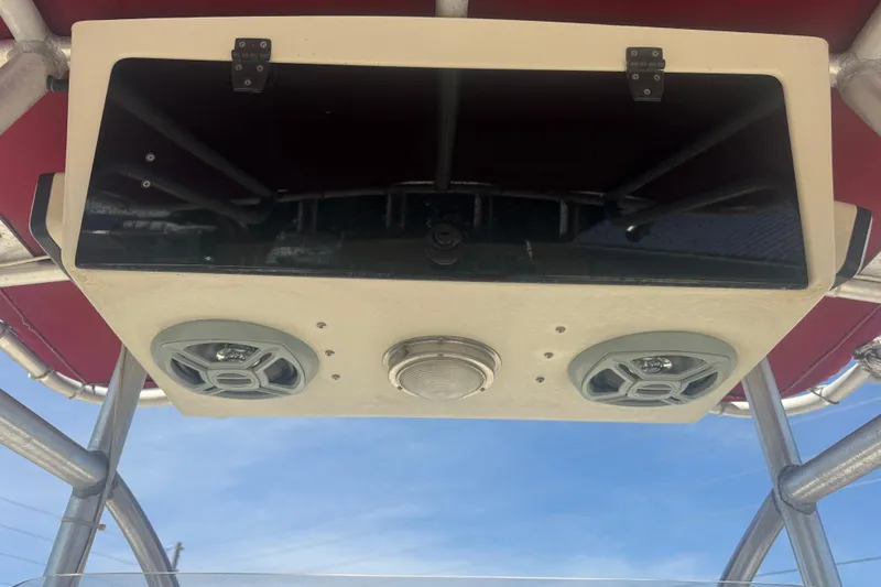 Slide: The Image of 1999 May-Craft 2500 boat console with speakers and storage, under a red canopy. - 10