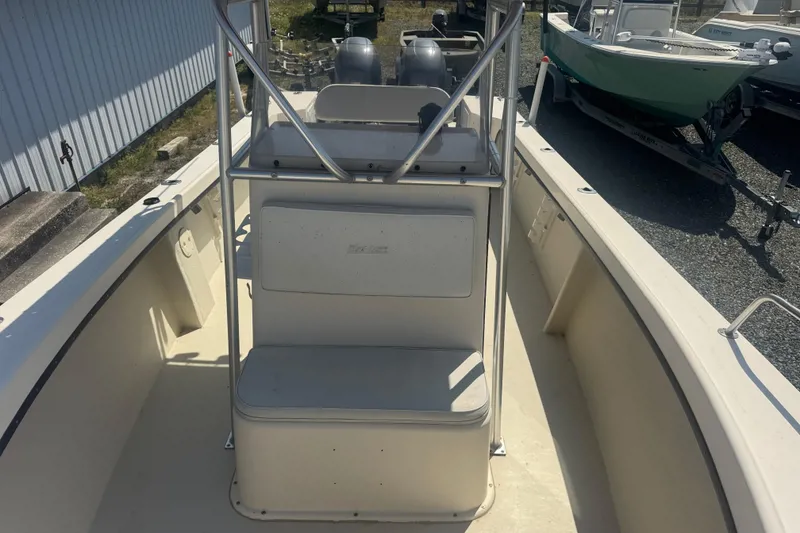 Slide: The Image of 1999 May-Craft 2500 boat interior with seating and console, parked outdoors. - 12