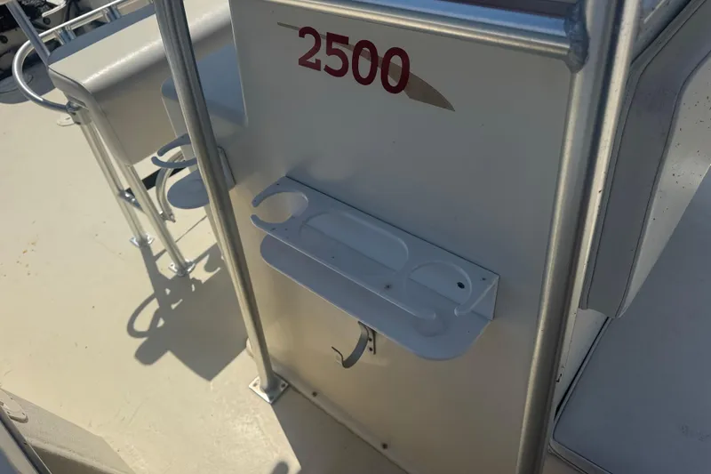 Slide: The Image of May-Craft 2500 boat interior, featuring cup holders and seating, 1999 model. - 14