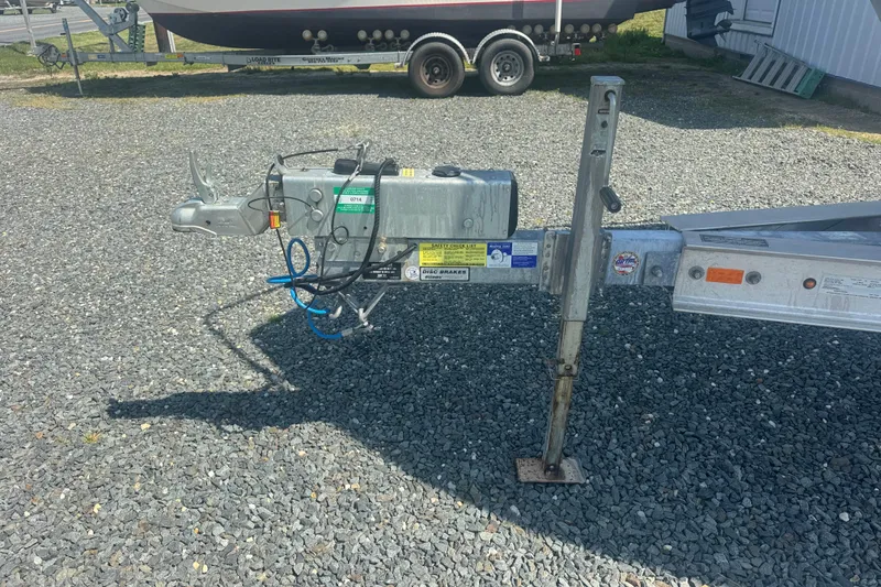 Slide: The Image of Trailer hitch of a 1999 May-Craft 2500 boat on gravel surface. - 2