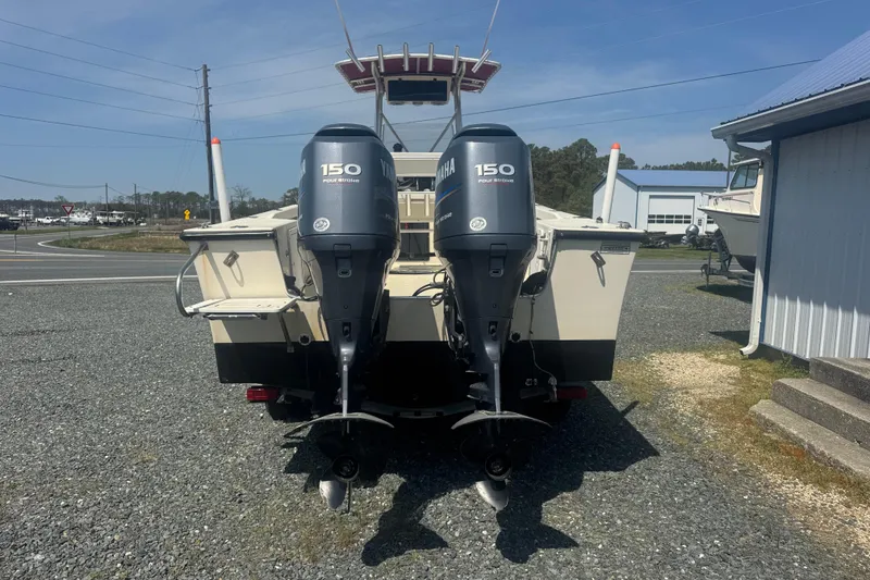 Slide: The Image of 1999 May-Craft 2500 boat with dual Yamaha 150 outboard motors, parked outdoors. - 3