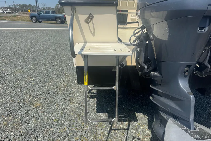 Slide: The Image of 1999 May-Craft 2500 boat with ladder and outboard motor on gravel surface. - 4