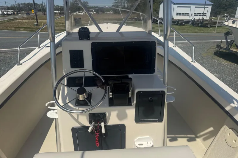 Slide: The Image of 1999 May-Craft 2500 boat cockpit with steering wheel and control panel. - 5