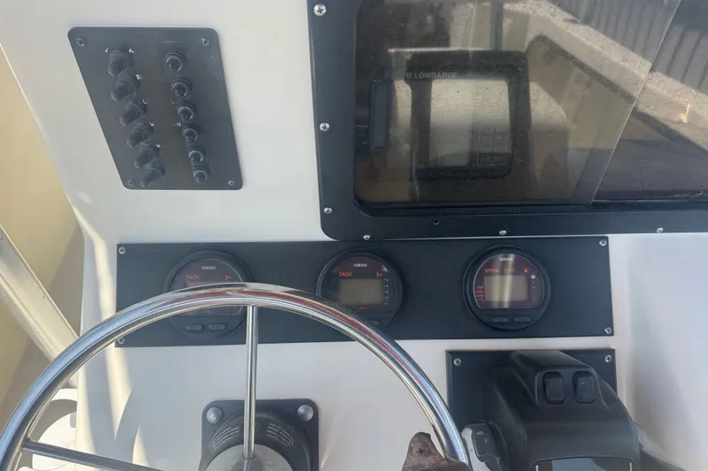 Slide: The Image of 1999 May-Craft 2500 boat dashboard with steering wheel and instrument panel. - 6