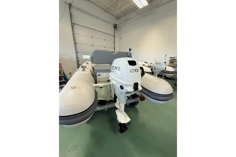 Slide: The Image of 2026 Desner Classic 310 FCT inflatable boat with Suzuki 20 HP outboard motor in a garage. - 5