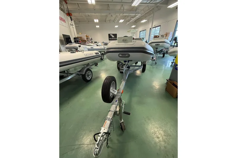 Slide: The Image of 2026 Desner Classic 310 FCT boat on trailer in showroom setting. - 8
