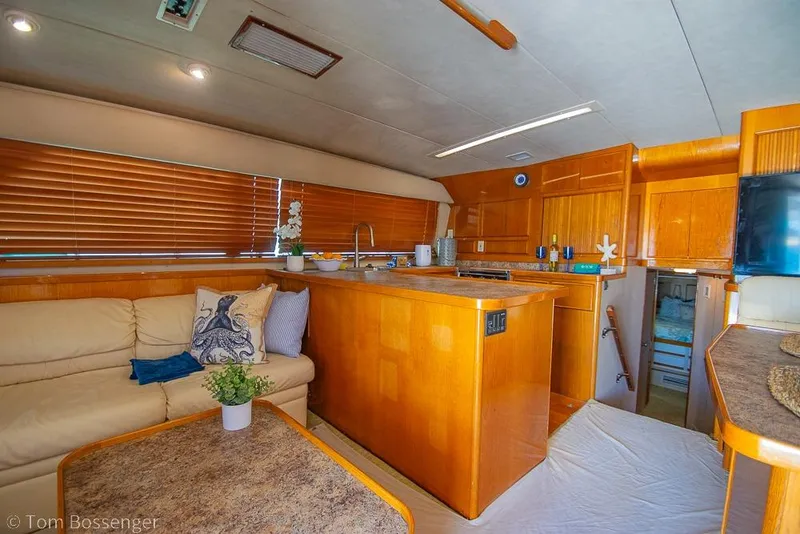 Slide: The Image of Interior of a 1989 Bertram 50 Convertible yacht with wooden cabinetry and cozy seating. - 10