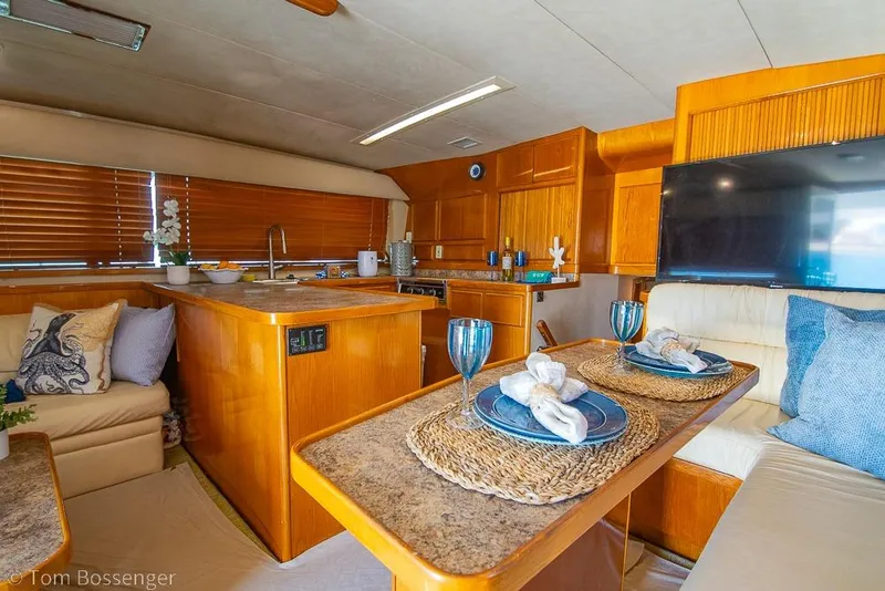 Slide: The Image of Interior of a 1989 Bertram 50 Convertible yacht with elegant dining setup. - 13