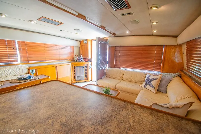 Slide: The Image of Interior of 1989 Bertram 50 Convertible yacht with cozy seating and wooden blinds. - 16