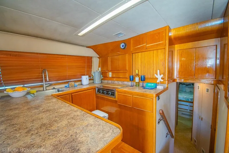 Slide: The Image of Interior of 1989 Bertram 50 Convertible yacht with wooden cabinetry and modern kitchen amenities. - 17