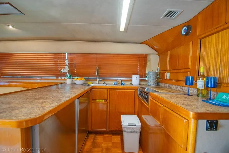 Slide: The Image of Interior of 1989 Bertram 50 Convertible yacht kitchen with wooden cabinetry and modern amenities. - 18