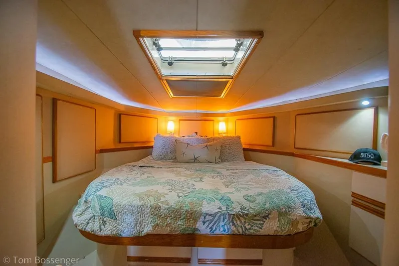 Slide: The Image of Cozy bedroom interior of 1989 Bertram 50 Convertible yacht with skylight and decorative bedding. - 23