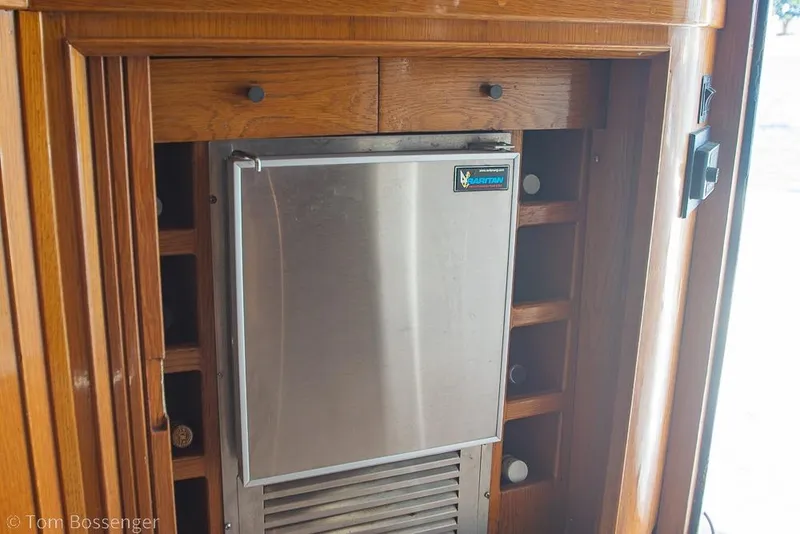 Slide: The Image of Built-in refrigerator on 1989 Bertram 50 Convertible yacht with wooden cabinetry. - 30