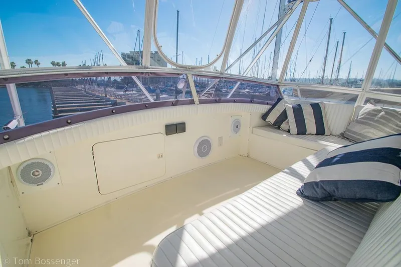 Slide: The Image of Interior view of 1989 Bertram 50 Convertible yacht with striped cushions and marina backdrop. - 48