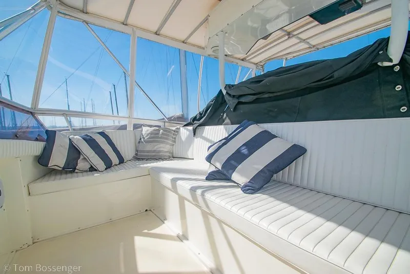 Slide: The Image of Interior of 1989 Bertram 50 Convertible yacht with striped cushions and panoramic windows. - 49