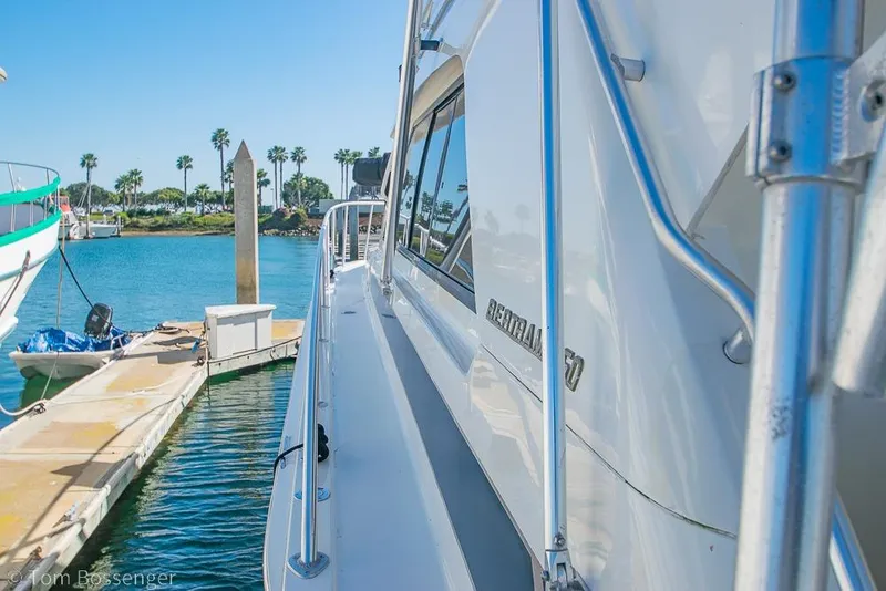 Slide: The Image of 1989 Bertram 50 Convertible yacht docked in a sunny marina with palm trees. - 52