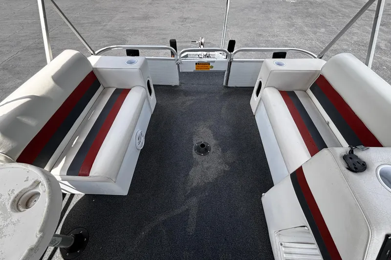 Slide: The Image of 2001 Godfrey Sweetwater 20 pontoon boat interior with red and gray striped seating. - 6