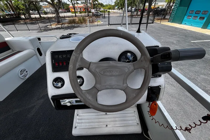 Slide: The Image of Steering console of a 2001 Godfrey Sweetwater 20 boat, featuring gauges and controls. - 9