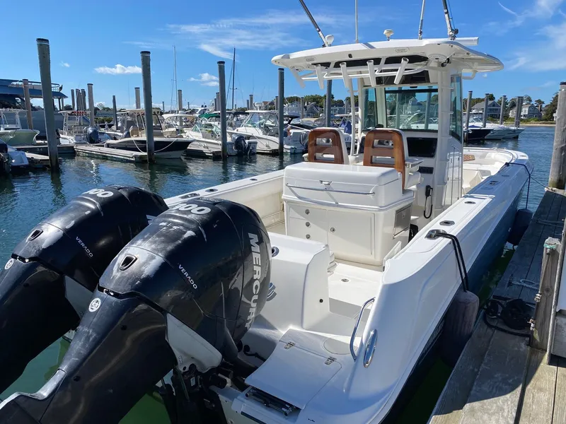 Slide: The Image of 2014 Boston Whaler 320 Outrage with twin engines docked at marina. - 2
