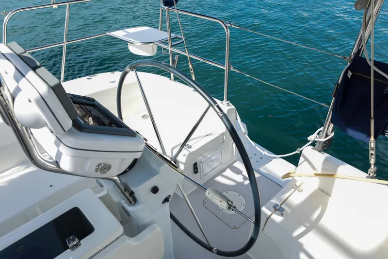 Slide: The Image of Cockpit of a 2010 Catalina 375 sailboat with steering wheel, overlooking blue water. - 12