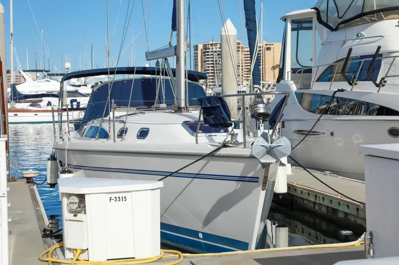 Slide: The Image of 2010 Catalina 375 sailboat docked at a marina, surrounded by other boats. - 2