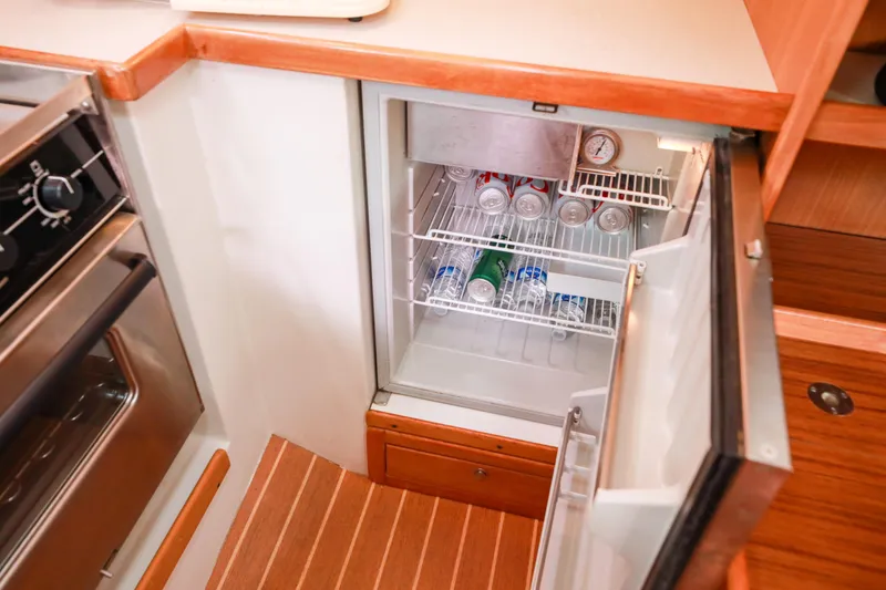 Slide: The Image of Small refrigerator in 2010 Catalina 375 yacht galley, stocked with canned beverages. - 37