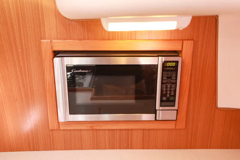 Slide: The Image of Built-in microwave in 2010 Catalina 375 yacht interior, featuring wood paneling and digital controls. - 40