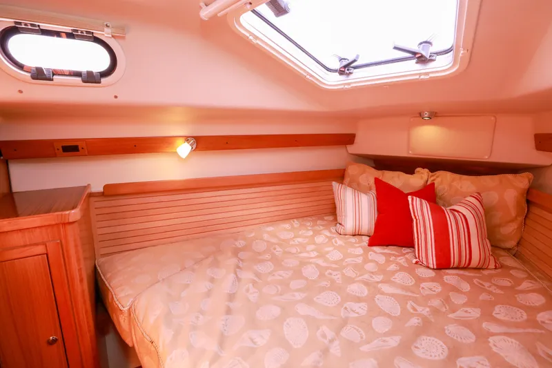 Slide: The Image of Cozy cabin interior of 2010 Catalina 375 sailboat with bed and decorative pillows. - 46