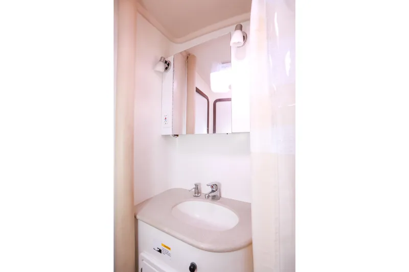 Slide: The Image of Bathroom sink area in a 2010 Catalina 375 yacht, featuring a mirror and faucet. - 51