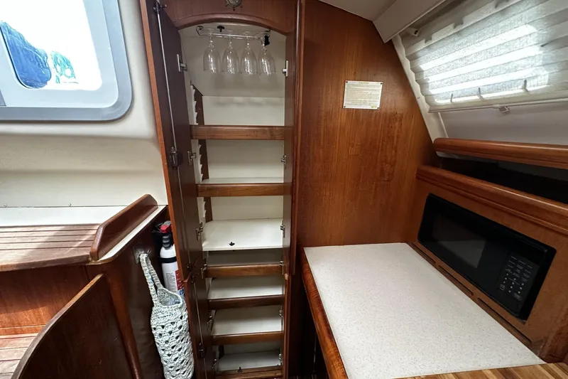Slide: The Image of Interior of 2004 Hunter 41 Aft Cockpit yacht with wooden cabinetry and microwave. - 19