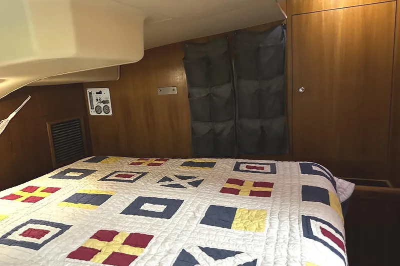 Slide: The Image of Interior of a 2004 Hunter 41 Aft Cockpit yacht with patterned bedding. - 26