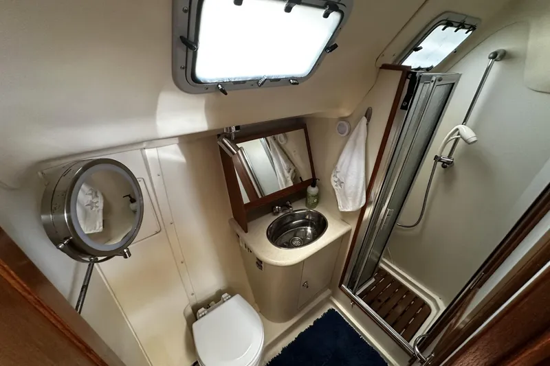 Slide: The Image of Compact bathroom in 2004 Hunter 41 Aft Cockpit yacht with shower, sink, and toilet. - 28