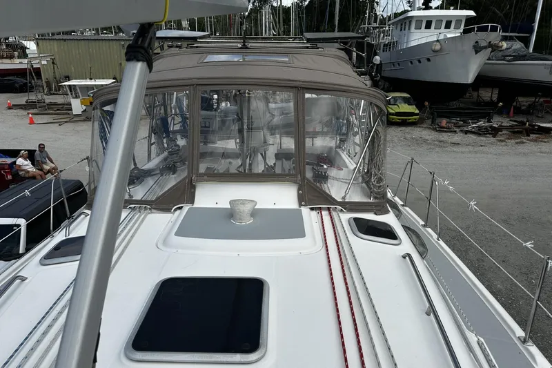 Slide: The Image of 2004 Hunter 41 Aft Cockpit sailboat in a boatyard, featuring a covered cockpit. - 3