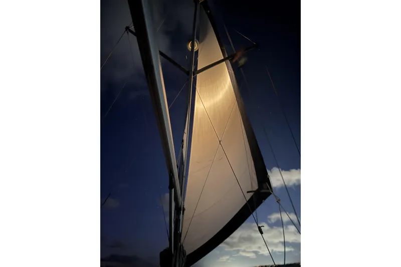 Slide: The Image of Sail of 2004 Hunter 41 Aft Cockpit yacht illuminated at night against a dark sky. - 54