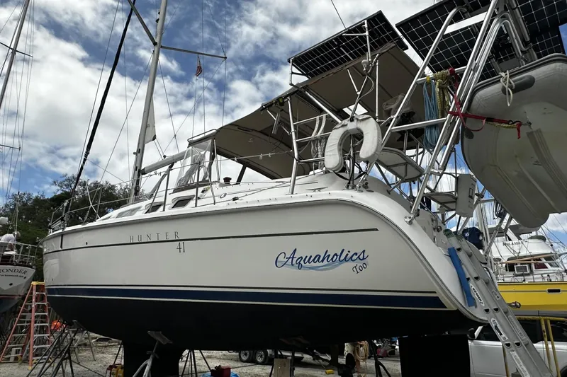 Slide: The Image of 2004 Hunter 41 Aft Cockpit sailboat named "Aquaholics" on dry dock with solar panels. - 55