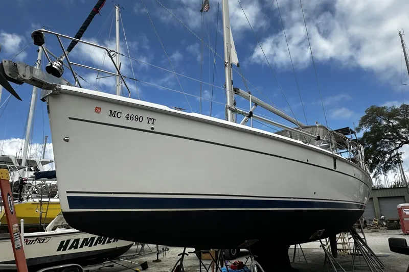 Slide: The Image of 2004 Hunter 41 Aft Cockpit sailboat on dry dock under a blue sky. - 57