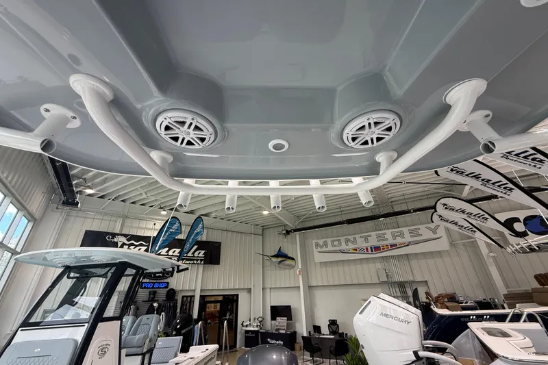Slide: The Image of 2026 Sportsman Open 232 Center Console boat displayed in a showroom with banners. - 14