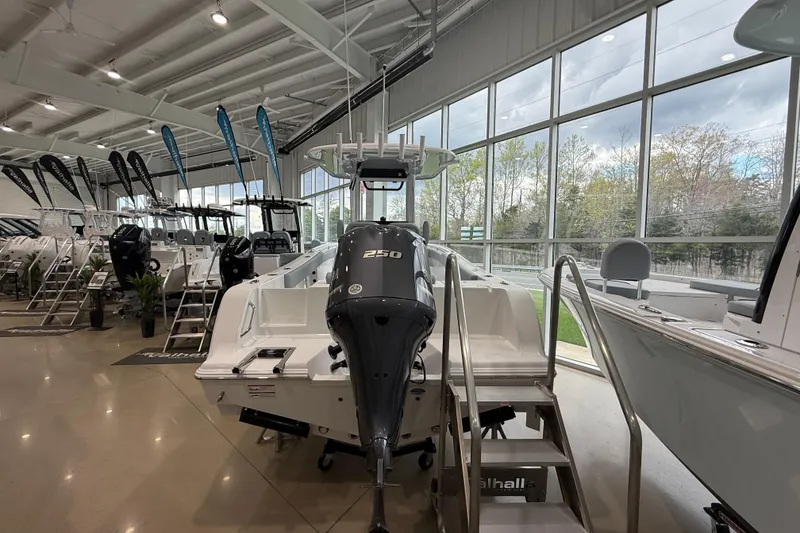 Slide: The Image of 2026 Sportsman Open 232 Center Console boat displayed in a showroom with large windows. - 4