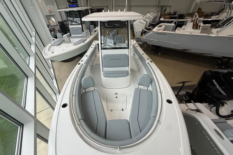 Slide: The Image of 2026 Sportsman Open 232 Center Console boat in showroom, featuring sleek design and spacious seating. - 5