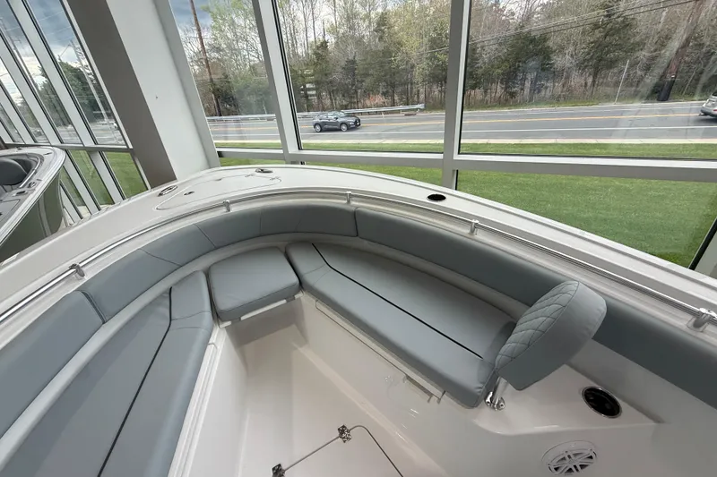 Slide: The Image of 2026 Sportsman Open 232 Center Console boat interior with cushioned seating in showroom. - 6