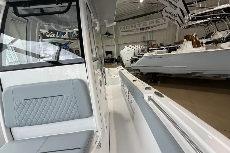 Slide: The Image of 2026 Sportsman Open 232 Center Console boat interior in showroom, featuring sleek seating and design. - 9