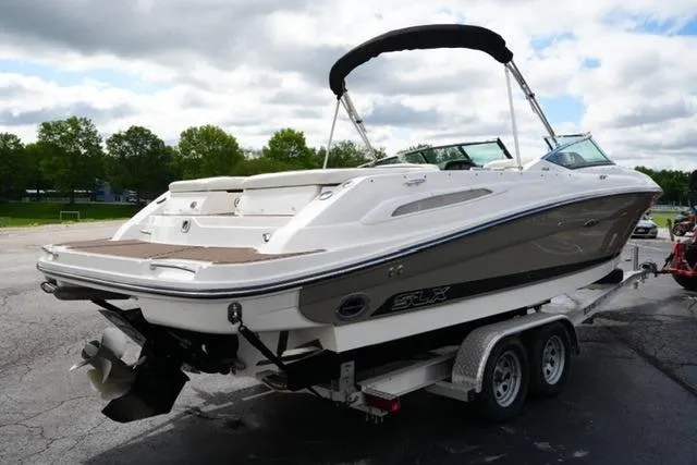 The Image of 2007 Sea Ray SLX 250 boat on trailer, parked outdoors under cloudy sky. - 1