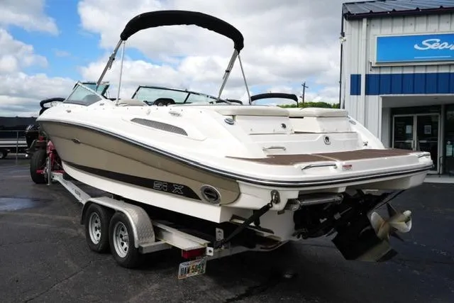 Slide: The Image of 2007 Sea Ray SLX 250 boat on trailer, parked outside dealership under cloudy sky. - 5
