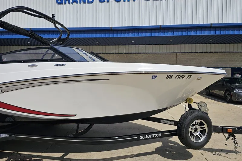 Slide: The Image of 2020 Glastron GTS 225 boat on trailer, parked outside a building. - 14