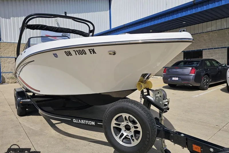 Slide: The Image of 2020 Glastron GTS 225 boat on trailer, parked outside a building. - 16