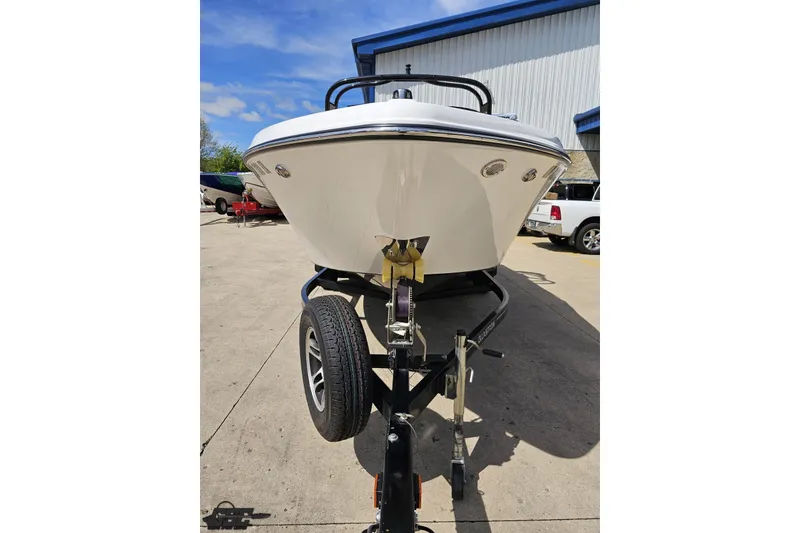 Slide: The Image of 2020 Glastron GTS 225 boat on trailer, parked outdoors near a building. - 17