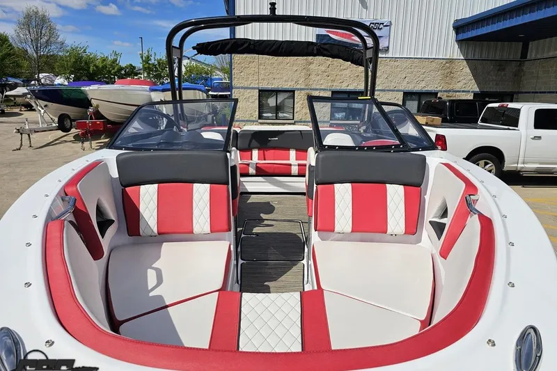 Slide: The Image of 2020 Glastron GTS 225 boat interior with red and white seating, parked outdoors. - 19