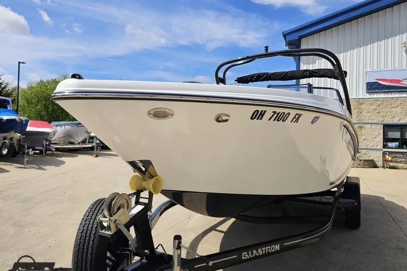 Slide: The Image of 2020 Glastron GTS 225 boat on trailer, parked outdoors under blue sky. - 20