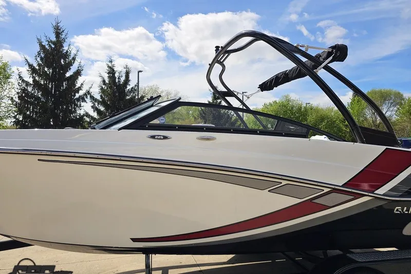 Slide: The Image of 2020 Glastron GTS 225 boat with sleek design, parked outdoors under a blue sky. - 25